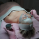 Professional esthetician applying blue facial treatment mask